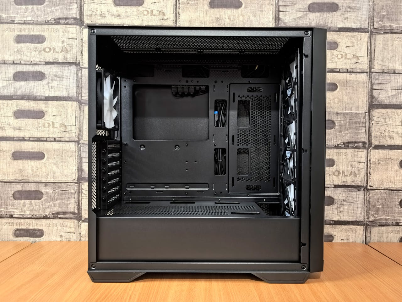 Black empty computer case on desk, ideal for gaming setup with visible airflow design.