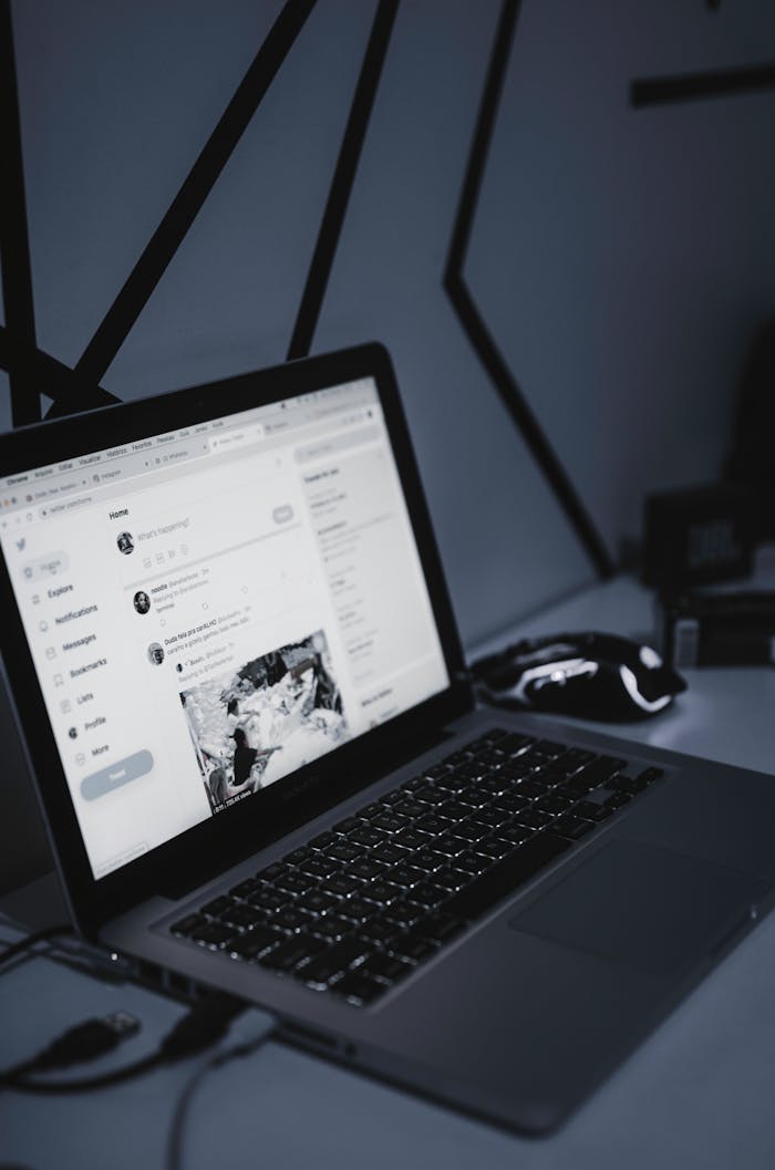 A sleek workspace featuring a laptop and a wireless mouse in a dimly lit room, fostering productivity.